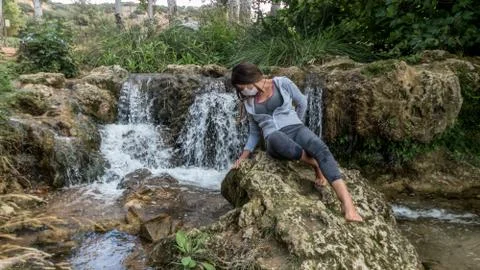 Mujer joven disfrutando de una hermosa cascada en las lagunas de ruidera Stock Photos