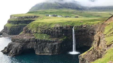 Mulafossur waterfall with Gasadalur village in the background in Vagar island Stock Footage