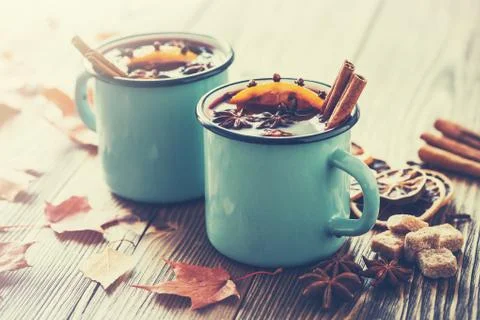 Mulled wine in blue enameled rustic mugs with spices and citrus fruits  Stock Photos