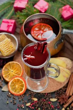 Mulled wine, blue pine tree branch and spices on wooden background Stock Photos