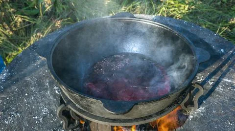 Mulled wine in a large cauldron. Mulled wine is cooked in a large pot. Vitami Stock Photos