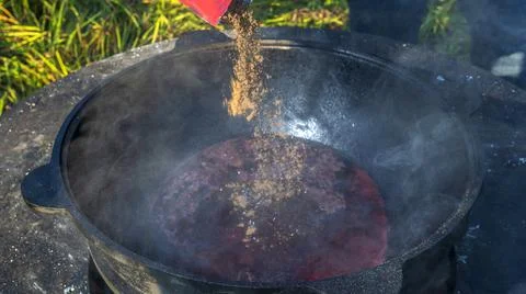Mulled wine in a large cauldron. Mulled wine is cooked in a large pot. Vitami Stock Photos