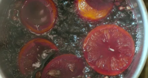 Mulled wine with spices, which is being prepared in a large old metal cauldron Stock Footage 150569415