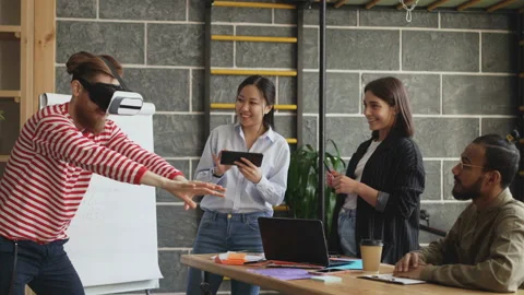 Mult ethnic team testing VR game simulator at modern office. Bearded hipster man Stock Footage 86640132