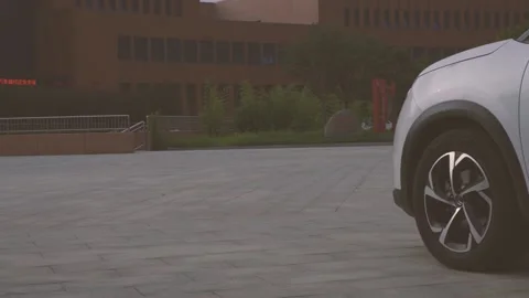Multi-angle video of a white city SUV parked in the square Stock Footage 156942976