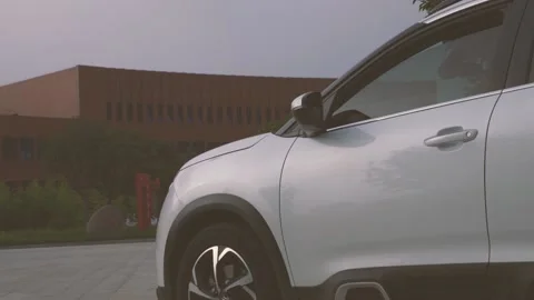 Multi-angle video of a white city SUV parked in the square Stock Footage 156943008