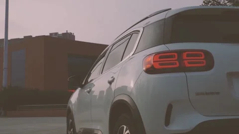 Multi-angle video of a white city SUV parked in the square Stock Footage 156943043