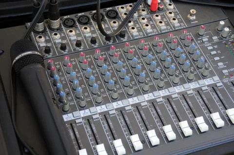 A multi-channel hardware audio mixer with microphone. Stock Photos