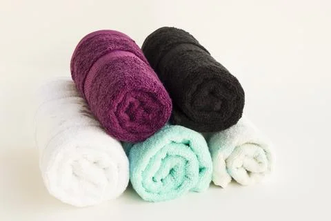 Multi color bath and face towels rolled up on white Stock Photos