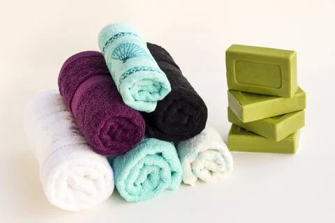 Multi color bath and face towels on white background with soaps Stock Photos
