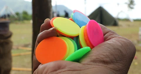 Multi Color Plastic Plain Tokens for Games in a hand Stock-Footage 327081116