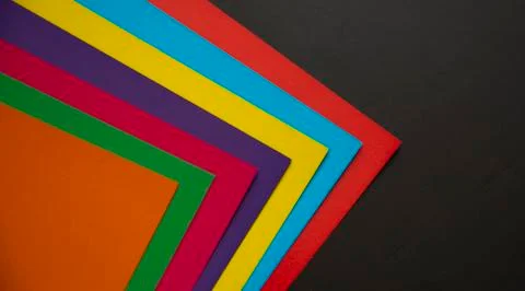 Multi-colored abstract geometric background. Colored sheets of paper on a bla Stock Photos
