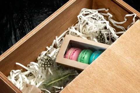 Multi-colored almond macaroni biscuits in a big gift box. Photos