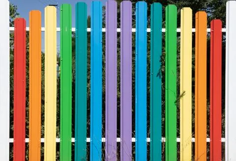 Multi-colored aluminum high railing against the blue sky and adult green spac Stock Photos