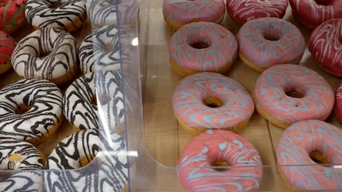 Multi-colored appetizing delicious fresh donuts on a store window. Different typ Stock Footage 297871076