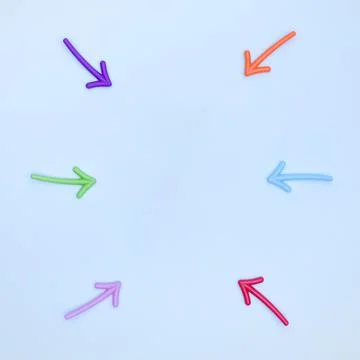 Multi-colored arrows pointing to the area between them on a light blue Stock Photos