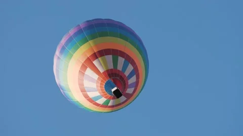 Multi-colored balloon flying in air against the blue sky Stock Footage 143287048
