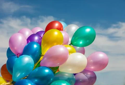 Multi-colored balloons on blue sky background Stock Photos