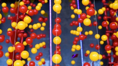 Multi-colored balls are stretched on ropes for decoration, swinging in the light Stock Footage 105987408