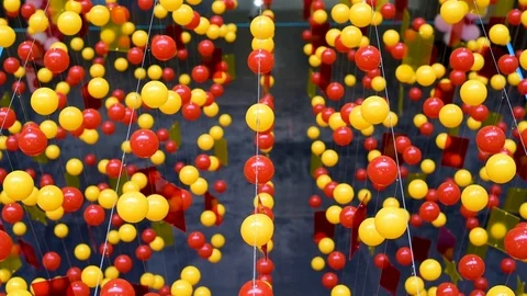 Multi-colored balls are stretched on ropes for decoration, swinging in the light Stock Footage 106014005