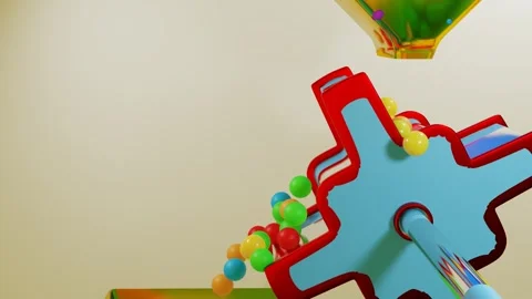 Multi-colored balls fall through a yellow funnel onto a rotating cylinder with b Stock Footage 253286927
