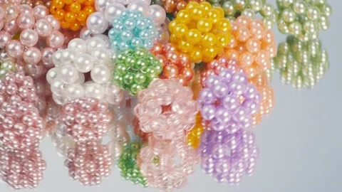Multi-colored balls of glossy beads on a mirror surface. 库存影片 173610913