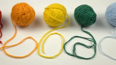 Multi-colored balls of threads for knitting lie in a row on a table 動画素材 270490245