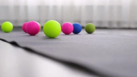 Multi-colored balls on the yoga mat, a ball for myofascial release rolls on the Stock Footage 165122681