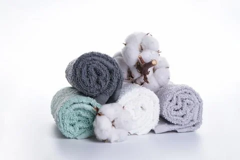 Multi-colored bath towels with a flower of cotton on a white background. Bath Stock Photos