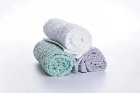 Multi-colored bath towels in a roll on a white background. Bath accessories.  Stock Photos