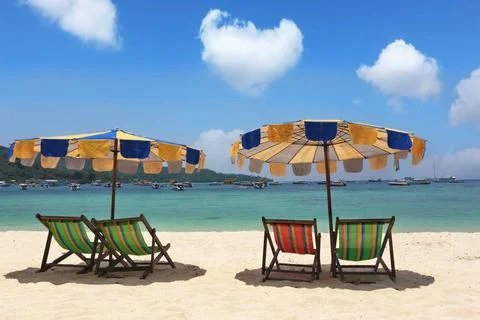 Multi-colored beach umbrellas and chaise lounges Beach paradise on island ... Stock-Fotos
