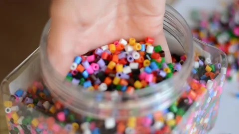 Multi-colored beads for crafts and a girl's hand Stock Footage 157045933