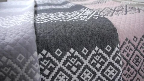 Multi-colored bedspreads laid out on the bed Stock Footage 282365707
