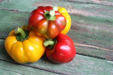 Multi-colored bell peppers on the background of boards Stock Photos
