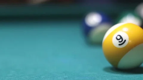 Multi-colored billiard balls scatter from a cue hit at the beginning of a game Stock Footage 339029279