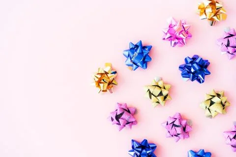 Multi colored bows for gift box wrapping on pink pastel background Stock Photos