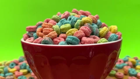 Multi Colored Breakfast Cereal Pieces Filling Red Bowl Against Bright Green Stock Footage 347151498