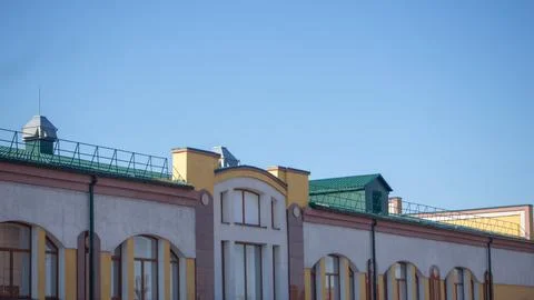 Multi colored brick building with a green roof against the sky. Elements of.. Stock Photos