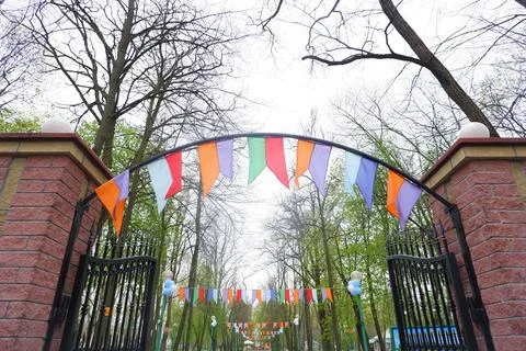 Multi-colored bright flags in front of the entrance to the park. Stock Photos