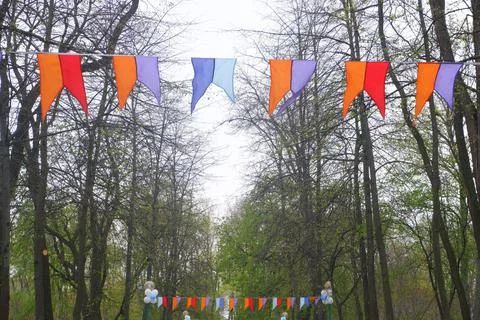 Multi-colored bright flags in front of the entrance to the park. Stock Photos