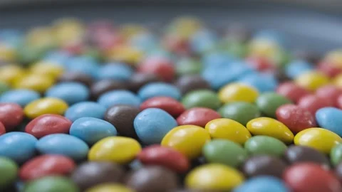 Multi-colored button-shaped bonbon chocolates with smooth rotation motion Stock Footage 296321194