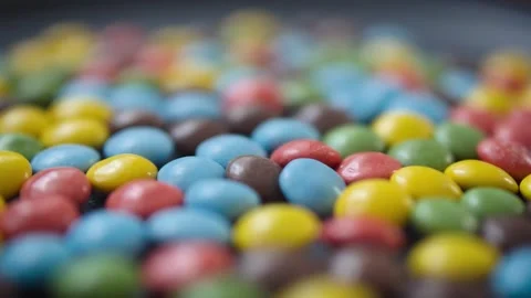 Multi-colored button-shaped bonbon chocolates with smooth rotation motion Video stock 296321195