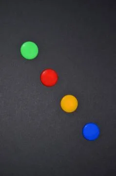 Multi-colored buttons on a black background. Stock Photos