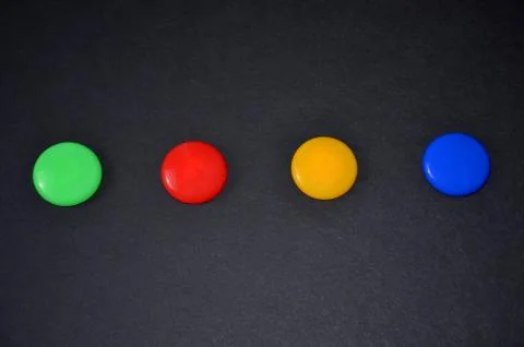 Multi-colored buttons on a black table. Stock Photos