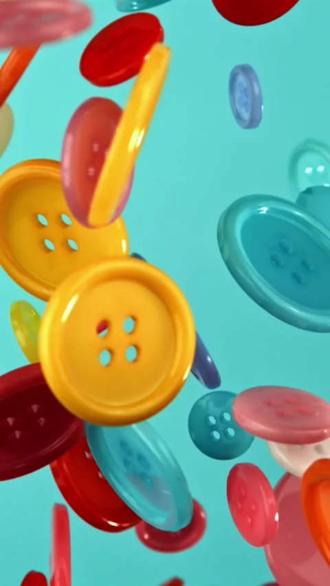 Multi-colored buttons fly on a blue background. Filmed on a high-speed camera at Stock Footage 335384025