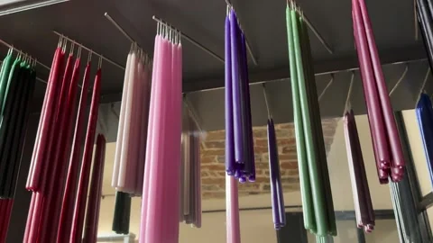 Multi-colored candles hand lights a blue candle from another flame during a Stock Footage 326465120