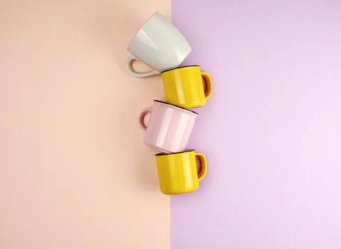 Multi-colored ceramic cups with a handle on an abstract pastel background Stock Photos