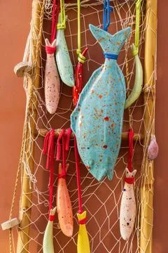 Multi-colored ceramic fish in decorative nets Stock Photos
