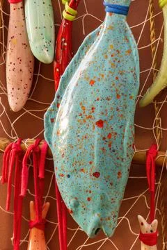 Multi-colored ceramic fish in decorative nets Stock Photos
