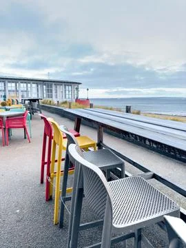 Multi-colored chairs on the terrace of a cafe by the sea. Stock Photos